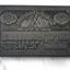 Metal rectangular plate has decorative border, text and images.