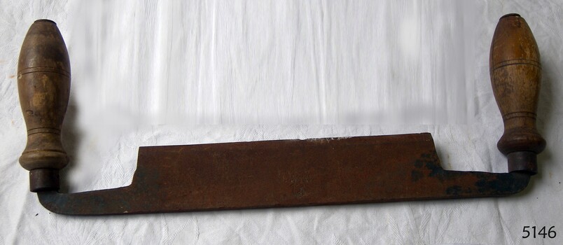 Draw knife has straight metal blade and bulbous wooden handles with scribed rings.