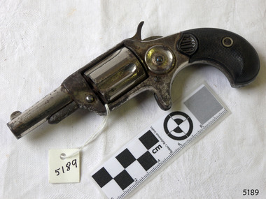 Pistol on bench, action on right, metal grip and barrel