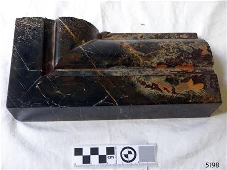 Black marble with light brown highlights, corner piece with carved border