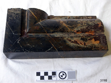 Black marble with light brown highlights, corner piece with carved border