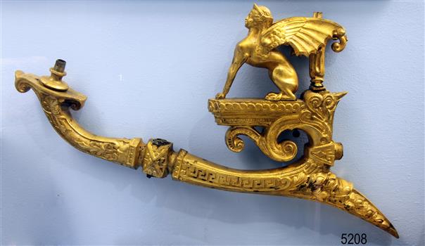 Gold coloured decorative gas wall bracket with a winged lion with a human head on top