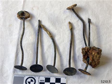 Set of six metal drink stirrers, shanks with disc on the end, bent, with encrustations on surfaces