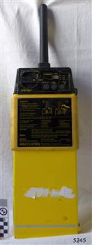 Rectangular yellow unit with black dials and information panel and black cylinder on top