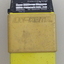 Yellow case has stamped brand across it. The top has a black panel with handwritten information