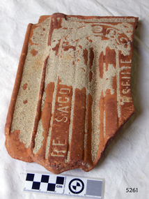 Orange terracotta roof tile with encrustations