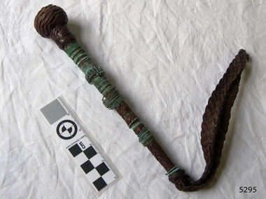 A rod with a cord on one end and a ball covered with copper wire on the other