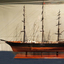 Ship model on wooden stand, no sails on the rigging.