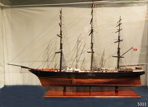 Ship model on wooden stand, no sails on the rigging.