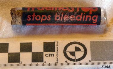 Glass container or vial with contents and cork, and label named Haemostop.