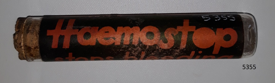 Glass container or vial with contents and cork, and label named Haemostop.
