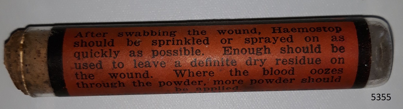Glass container or vial with contents and cork, and label named Haemostop.
