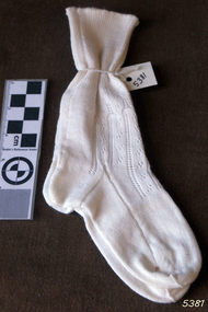 A pair of white, calf length hand-knitted socks