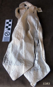 Long white fabric, narrow in the centre and flared out to a wide point at each end