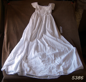 Child's white gown with short sleeves and long skirt, decorated with embroidery and lace