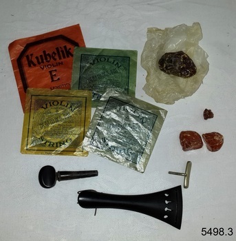 Four square coloured packets and several accessories including wax, laid out on a table