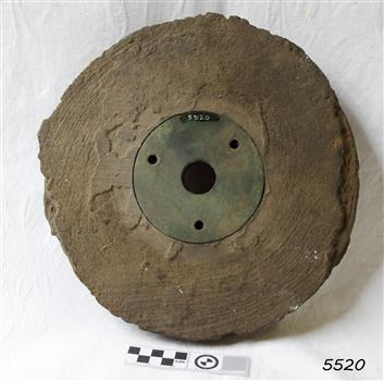Wooden pully sheeve, petrified,  with metal disc in centre