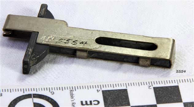 The binder is metal and shaped as a 'T' with an oval hole for fitting into place