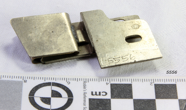 Metal plate has a raised top and cutout ovals for attachment