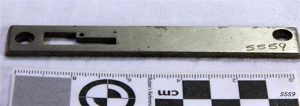Needle plate is made from a bar of metal with various holes for adjusting and attaching