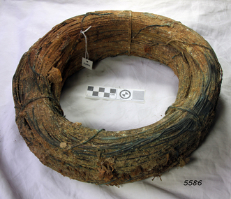 Wire is rolled into a compact bundle. It has concretion and encrustations