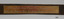 Gold coloured plaque with inscription in script wriging