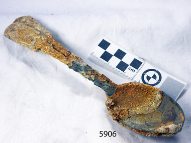 Two metal spoons joined by encrustations from the sea