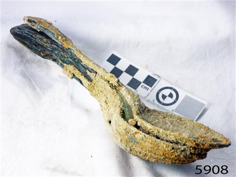 Spoons stuck together golden in colour covered in black and green marks and sea crustaceans
