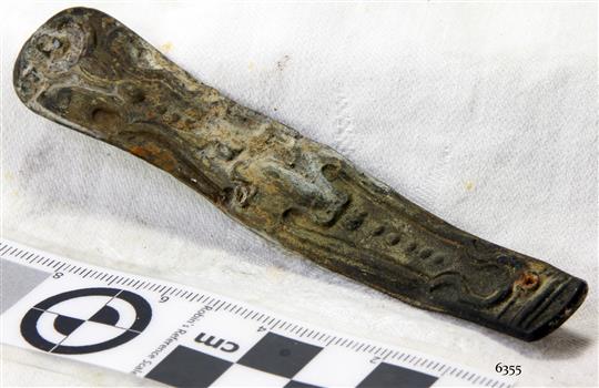 Part of a pocket knife with fancy design impressed in metal