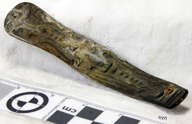 Part of a pocket knife with fancy design impressed in metal