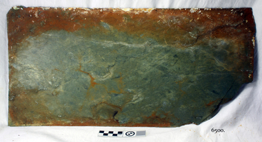 Slate tile has colours of browns and blue-green. The corner is broken off.