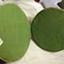 Two green fabric covered circles are joined at the edges for a short distance, creating a book-like case