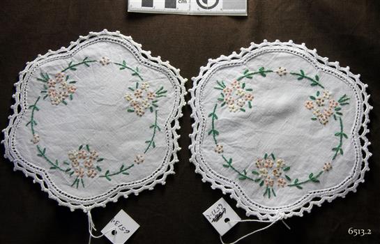 Pair of scalloped round doilies with brown, yellow and green floral embroidery and chrcheted edge