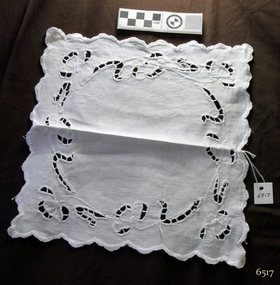 Square white cloth doily with cutwork, embroidery and scalloped edges