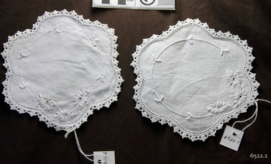 White doilies with white embroidery and crocheted edging