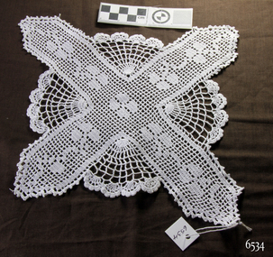 Crocheted doily designed as a Maltese Cross, an X and an O intertwined
