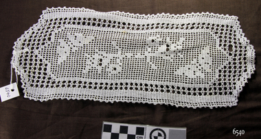 White crocheted doily with butterfly and floral motifs