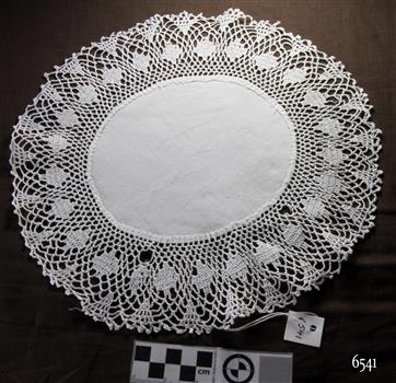 Oval white cotton doily with wide crocheted border