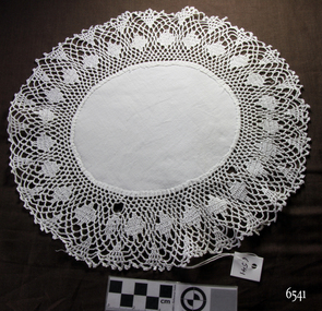 Oval white cotton doily with wide crocheted border