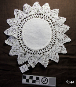 White cotton fabric circle with wide embroidered border with points, like a sun