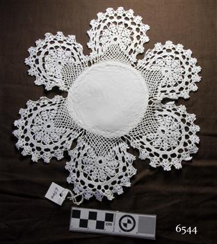 Round white fabric centre with six circular crochet pieces forming a border