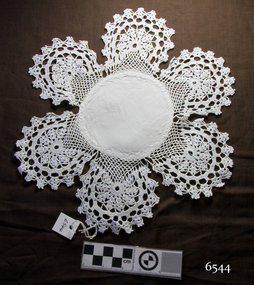 Round white fabric centre with six circular crochet pieces forming a border