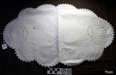 White embroidered tray cover, oval shape with scalloped edges decorated with crocheted trim