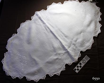 White cloth, embroidered tray cover, oval shaped with scalloped edges and crocheted border