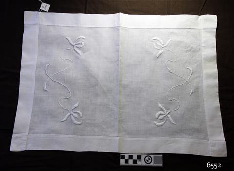 White rectangular cotton tray cover with wide hem and embroidered floral motif