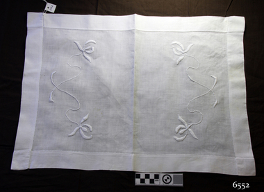 White rectangular cotton tray cover with wide hem and embroidered floral motif