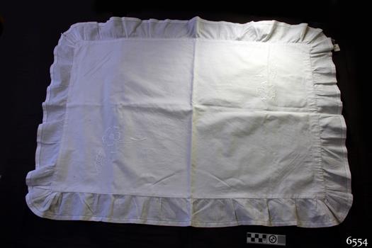 White cotton rectangular ruffled pillow case with embroidered floral motifs