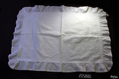 White cotton rectangular ruffled pillow case with embroidered floral motifs