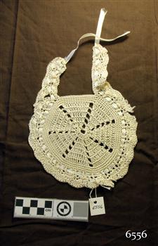 Cream coloured crocheted bib with ribbon trim and tie