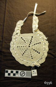 Cream coloured crocheted bib with ribbon trim and tie